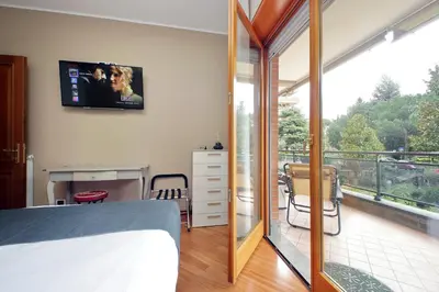 a bedroom with a balcony with a television on the wall at Aurelia Relax Apartment in Rome
