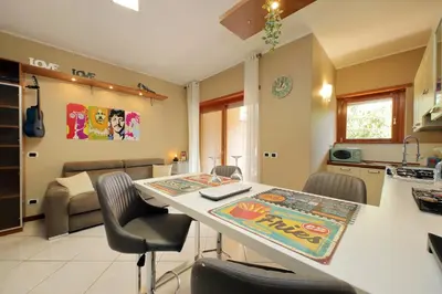 a kitchen and living room with a table and chairs at Aurelia Relax Apartment in Rome