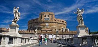 people walking across a bridge in front of a building at Termini Palace Guesthouse in Rome
