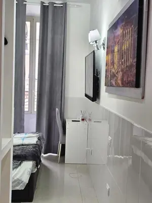 a room with a bed and a table and a chair at Termini Palace Guesthouse in Rome