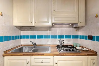 a kitchen with white cabinets and a sink at Rome As You Feel - Cancelleria Apartment in Navona in Rome