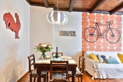 a dining room with a table and a bike on the wall at Rome As You Feel - Cancelleria Apartment in Navona in Rome