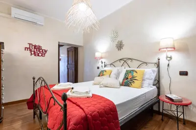 a bedroom with a bed with a red blanket at Rome As You Feel - Cancelleria Apartment in Navona in Rome