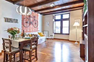 a living room with a table and a bike on the wall at Rome As You Feel - Cancelleria Apartment in Navona in Rome