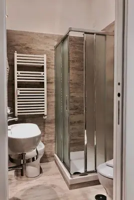 a bathroom with a shower and a toilet and a sink at Audrey's Roman Holidays - Rome Suites & Rooms in Rome