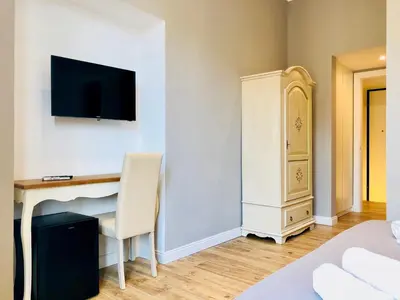 a bedroom with a desk and a tv on a wall at Audrey's Roman Holidays - Rome Suites & Rooms in Rome