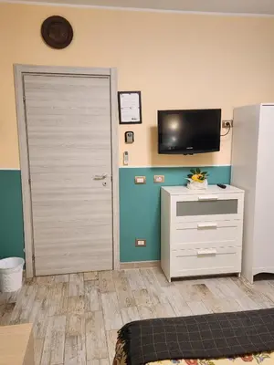 a room with a door and a tv and a dresser at Le terrazze di Alberto in Rome