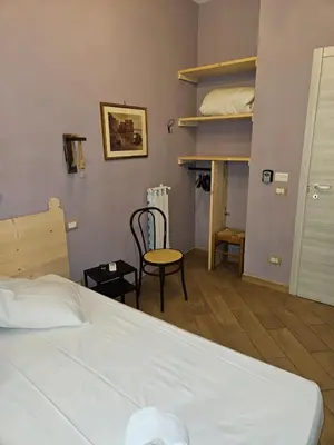 a bedroom with a bed and a chair and a closet at Le terrazze di Alberto in Rome