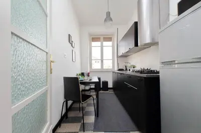 a kitchen with a small table and a kitchen with black cabinets at Triumph Apartment in Rome