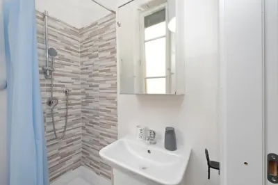 a white bathroom with a sink and a shower at Triumph Apartment in Rome