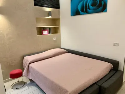 a small room with a bed and a red stool at Chroma Apt Farinone 28 in Rome