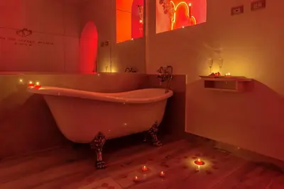 a bathroom with a tub with candles on the floor at Ripetta Luxury Del Corso in Rome