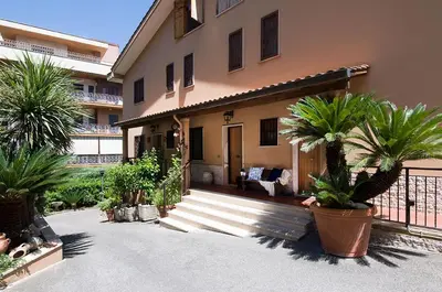 a house with palm trees in front of it at Olympic Suite Roma in Rome