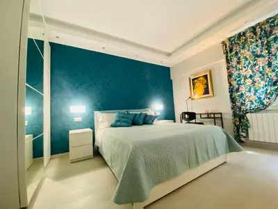 a bedroom with a bed and a blue wall at Olympic Suite Roma in Rome