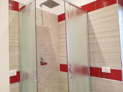 a shower with a glass door in a bathroom at In Rome Trastevere Rooms in Rome