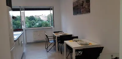 a kitchen with two tables and chairs and a window at In Rome Trastevere Rooms in Rome