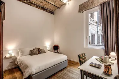 a bedroom with a bed and a table and a window at Farnese House in Rome in Rome