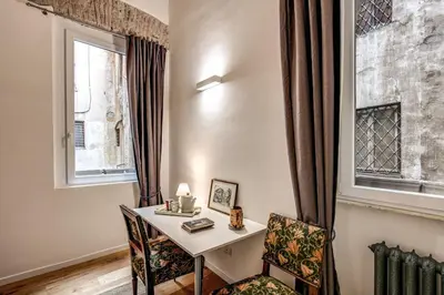 a room with a table and two chairs and a window at Farnese House in Rome in Rome