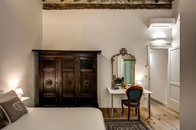 a bedroom with a bed and a desk and a mirror at Farnese House in Rome in Rome
