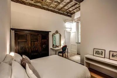 a bedroom with a bed and a desk with a mirror at Farnese House in Rome in Rome