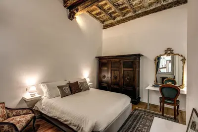 a bedroom with a bed and a mirror and a chair at Farnese House in Rome in Rome