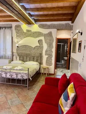 a living room with a bed and a red couch at Rione Di Roma Center Apartment in Rome