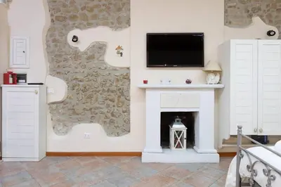 a living room with a fireplace and a tv on a wall at Rione Di Roma Center Apartment in Rome