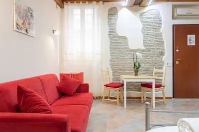 a living room with a red couch and a table at Rione Di Roma Center Apartment in Rome