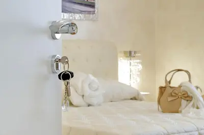 a bedroom with a white bed with a purse on it at Luxury Rome Guest House in Rome