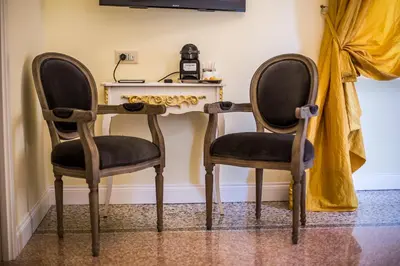 two chairs sitting next to a table in a room at Trastevere Royal Suite Trilussa in Rome