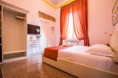 a bedroom with a bed with orange curtains and a window at Trastevere Royal Suite Trilussa in Rome