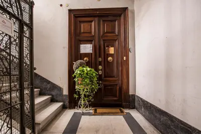 a wooden door in a building with a plant at Trastevere Royal Suite Trilussa in Rome