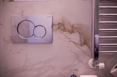 a bathroom with two rings on a marble wall at Trastevere Royal Suite Trilussa in Rome