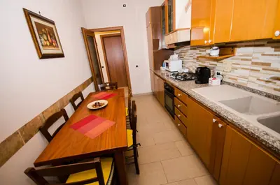 a small kitchen with a wooden table and a sink at Hello Rose - Appartamento intero in Rome