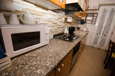 a kitchen with a microwave on top of a counter at Hello Rose - Appartamento intero in Rome
