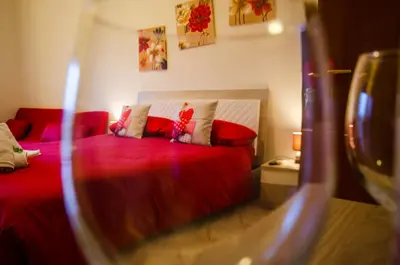 a bedroom with a bed with red sheets and pillows at Hello Rose - Appartamento intero in Rome