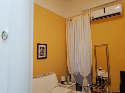 a living room with a white couch and a mirror at My Trevi Rooms 88 in Rome