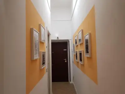 a hallway with pictures on the walls and a black door at My Trevi Rooms 88 in Rome