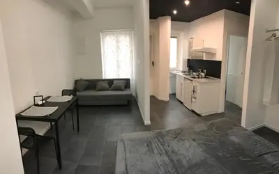 a living room with a couch and a table and a kitchen at Ale 160 in Rome