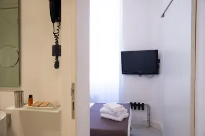 a room with a television and a bed with a chair at Residenza Pantaleo in Rome
