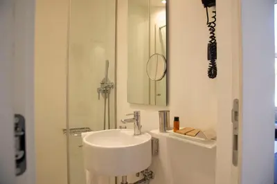 a white bathroom with a sink and a mirror at Residenza Pantaleo in Rome