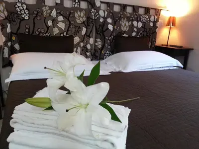 a pile of towels and a flower on a bed at San Lorenzo Rooms in Rome