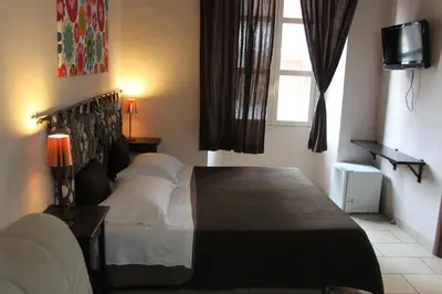 a bedroom with a bed and a television and a window at San Lorenzo Rooms in Rome