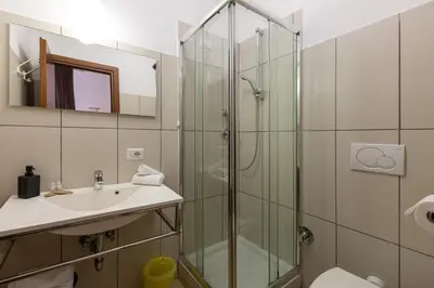 a bathroom with a glass shower and a sink at San Lorenzo Rooms in Rome