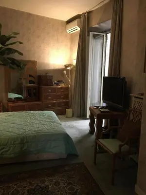 a bedroom with a bed and a desk and a television at Elle house Roma in Rome