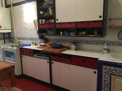 a kitchen with red and white cabinets and a sink at Elle house Roma in Rome