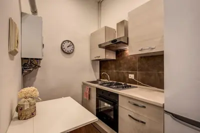 a kitchen with a stove and a clock on the wall at Guest House o Affittacamere La Civetta di Trastevere B in Rome