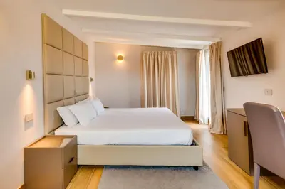 a hotel room with a white bed and a window at V Collection Relais Badoer in Rome