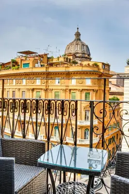 a glass table in front of a building at V Collection Relais Badoer in Rome