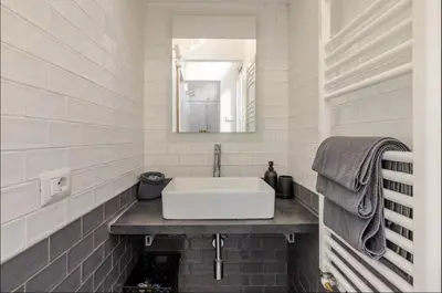 a white bathroom with a sink and a mirror at Rome Apartment San Pietro - Monte del Gallo in Rome